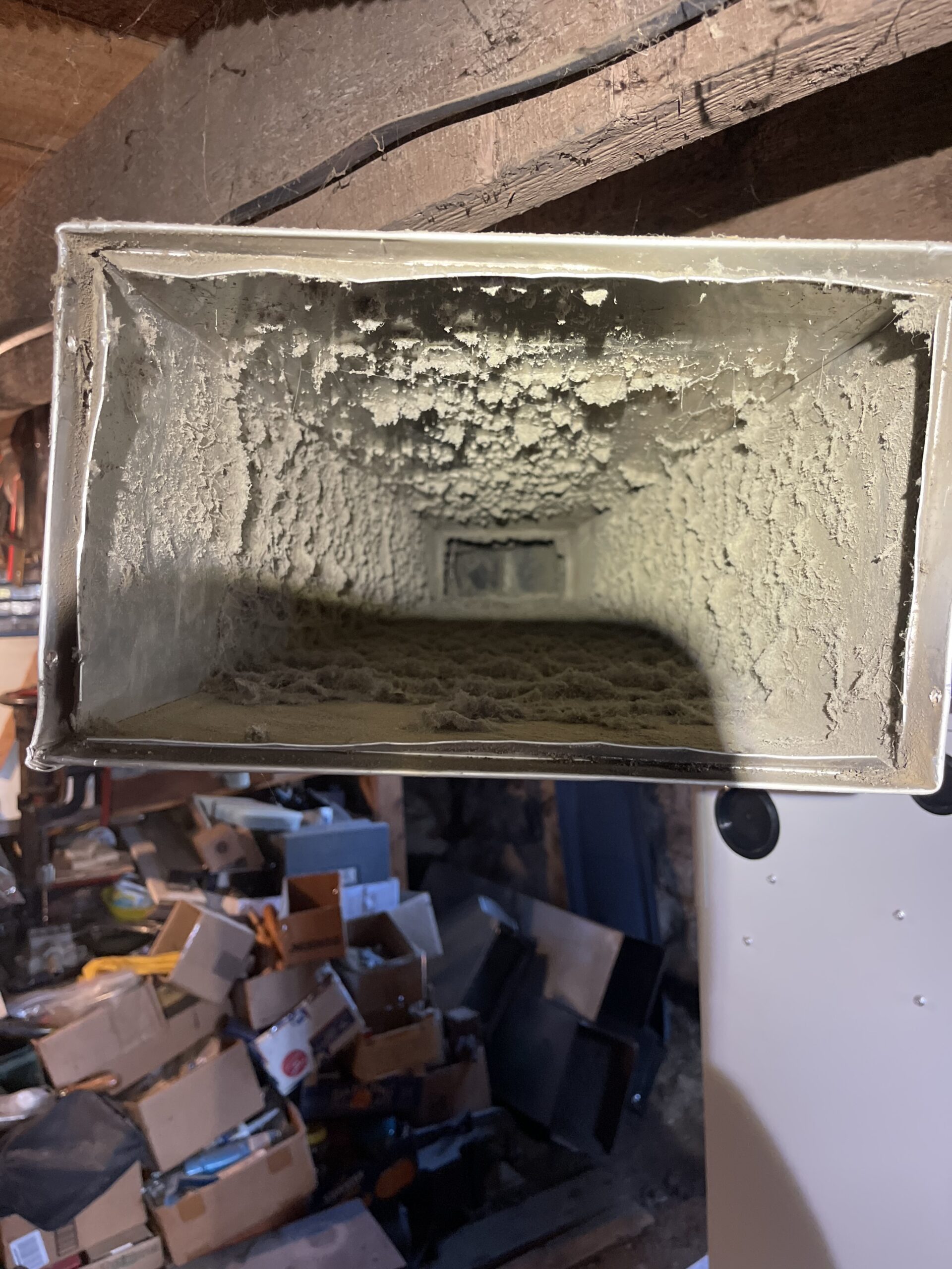 Heavy dust and debris buildup inside residential air duct before cleaning