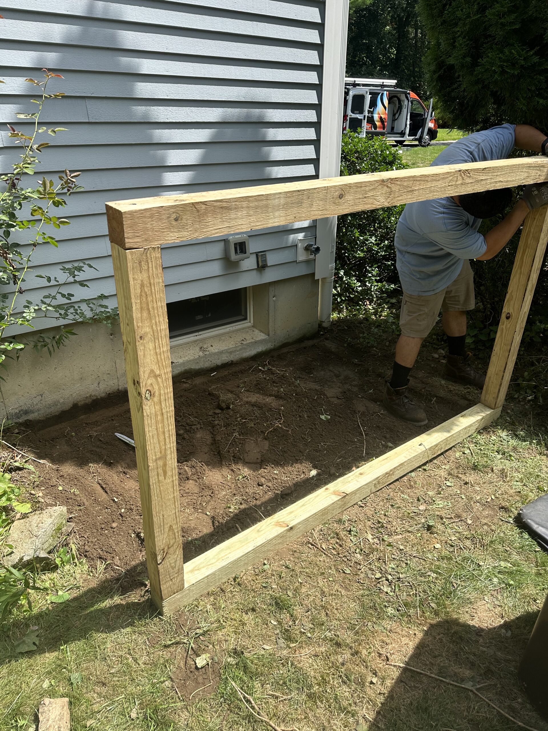 EML Mechanical technician building a wood frame for an outdoor HVAC equipment base