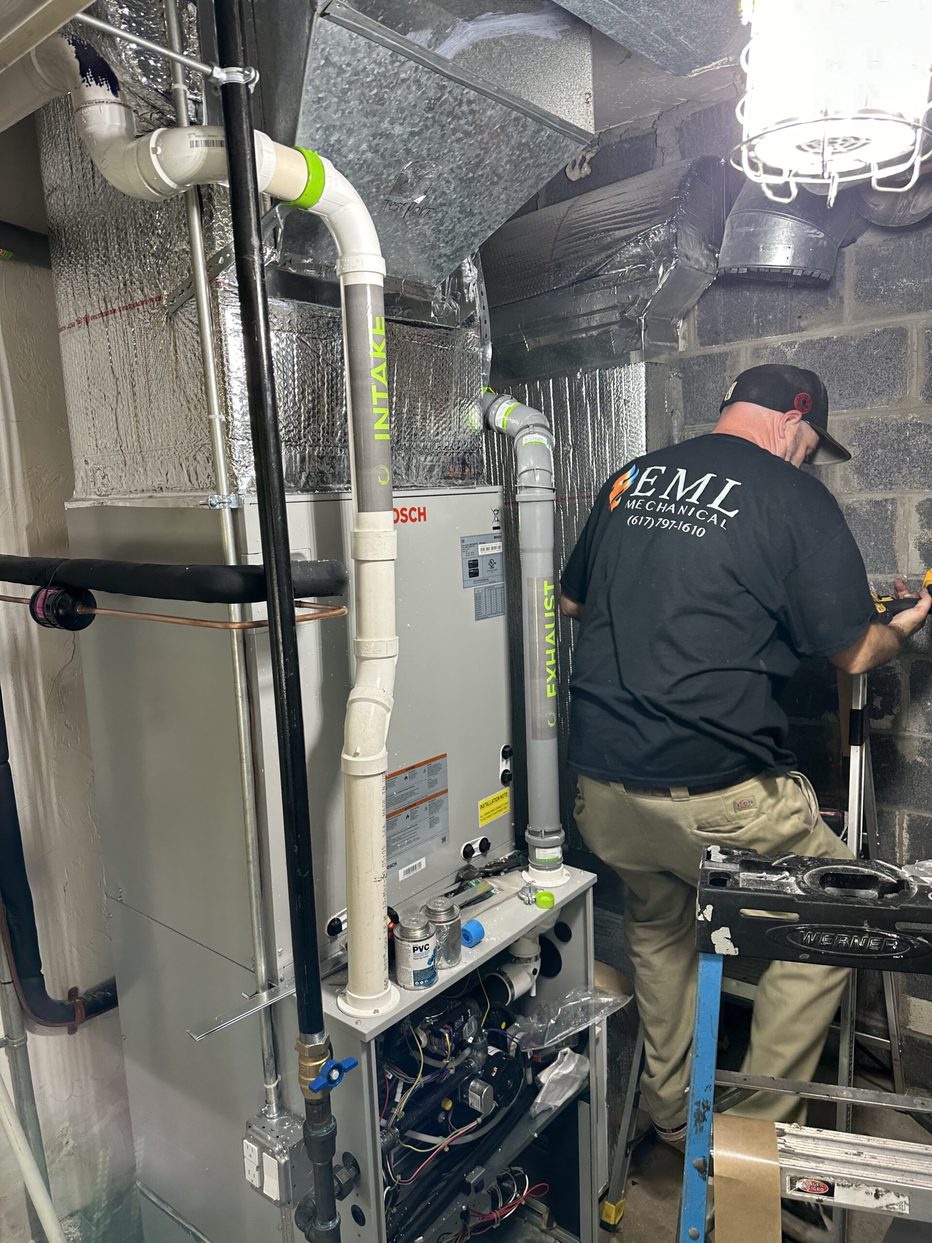 EML Mechanical technician installing a high-efficiency furnace